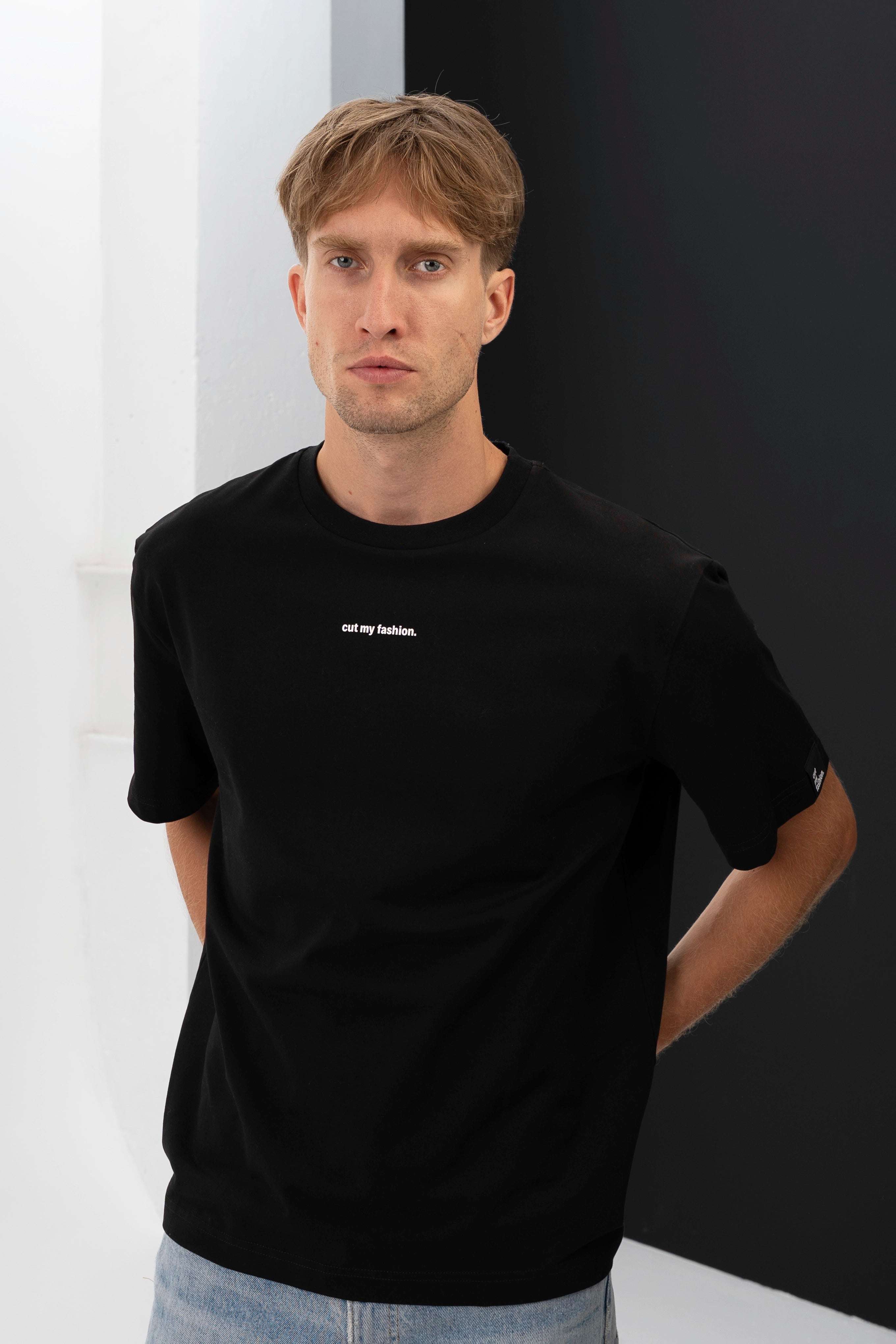 Juodi oversized marškinėliai iš priekio, subtilus minimalistinis dizainas su baltu logotipu krūtinėje