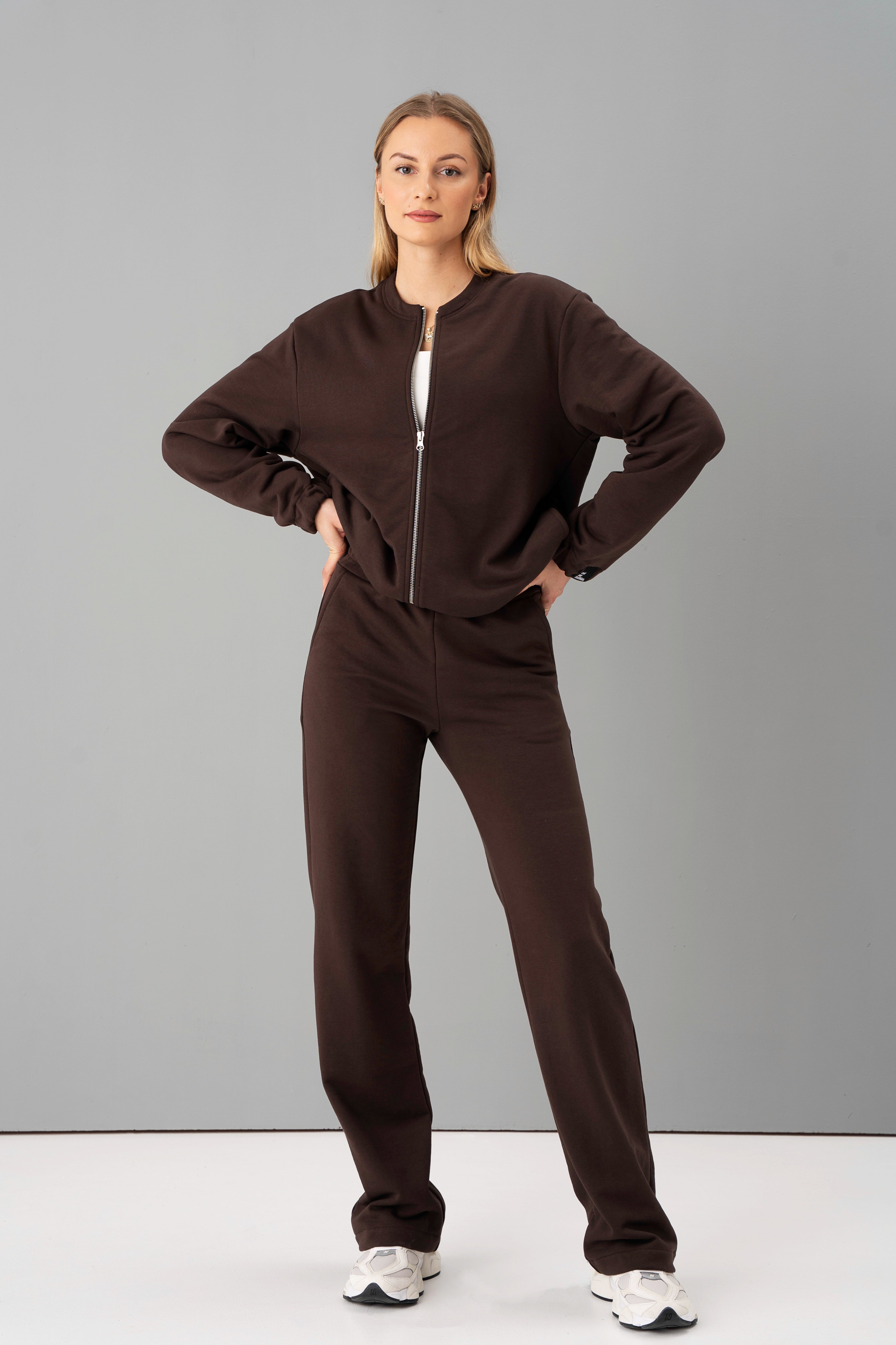 moteris vilki rudos spalvos cutmyfashion laisvalaikio treningus be pūkelio, stovi studijos fone, žiūri į kamerą